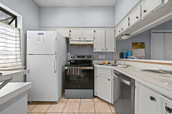 a kitchen with a white cabinets and white appliances