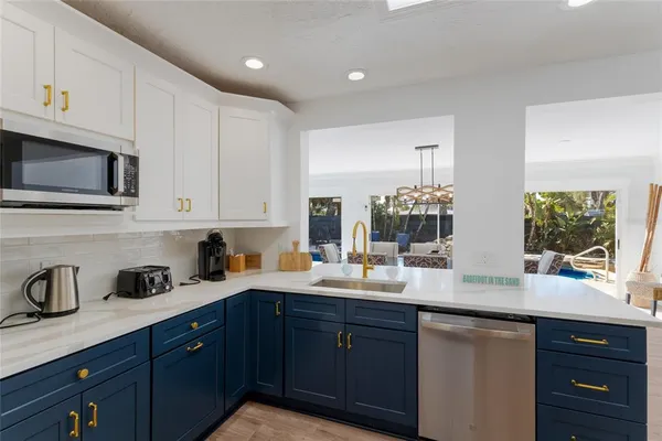 a kitchen with granite countertop kitchen island stainless steel appliances sink stove and refrigerator