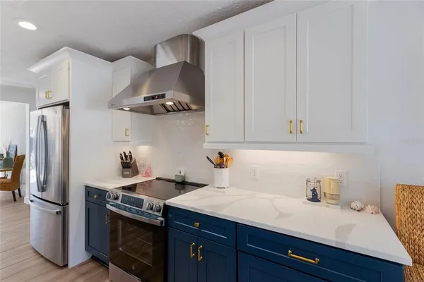 a kitchen with stainless steel appliances kitchen island granite countertop a table chairs and a refrigerator