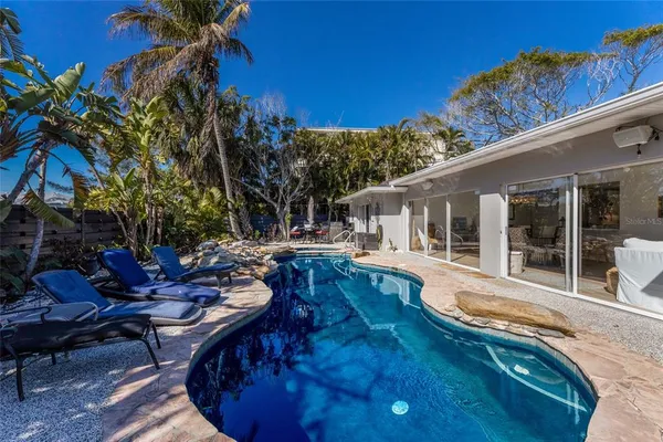 a view of swimming pool with outdoor seating and plants