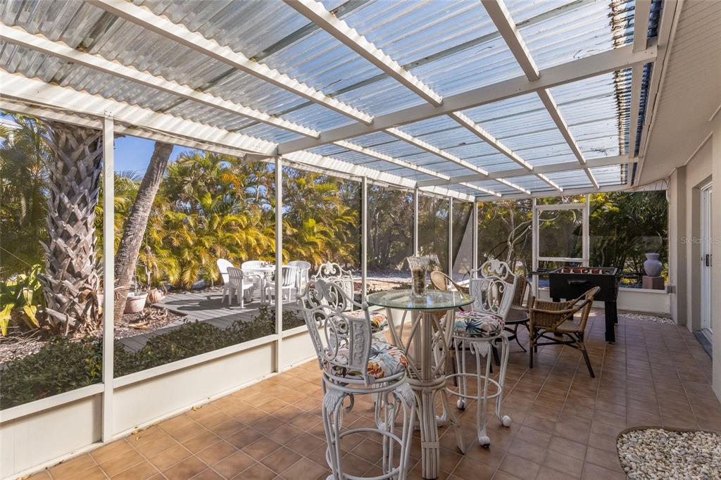 419 Clark Drive Holmes Beach, FL 34217 - Photo 40 of 53 a view of a patio with table and chairs and potted plants