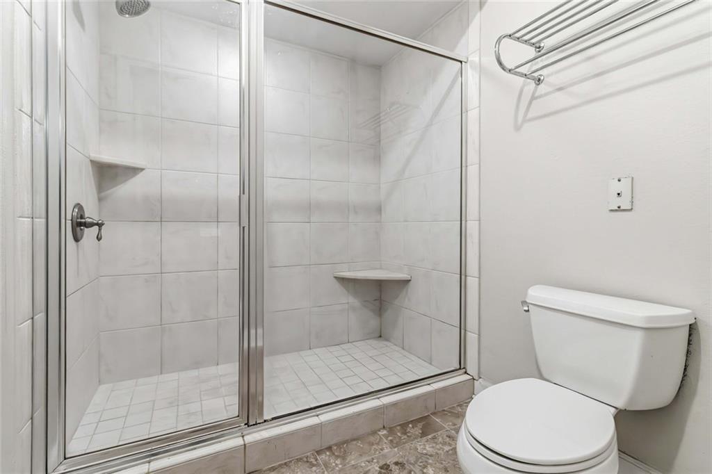 3777 Peachtree Road Northeast, Unit 533 Brookhaven, GA 30319 - Photo 19 of 30 a white toilet sitting next to a shower