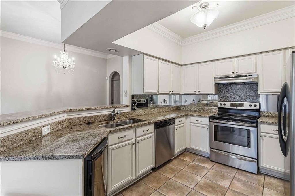 3777 Peachtree Road Northeast, Unit 533 Brookhaven, GA 30319 - Photo 23 of 30 a kitchen with granite countertop a sink stainless steel appliances and cabinets