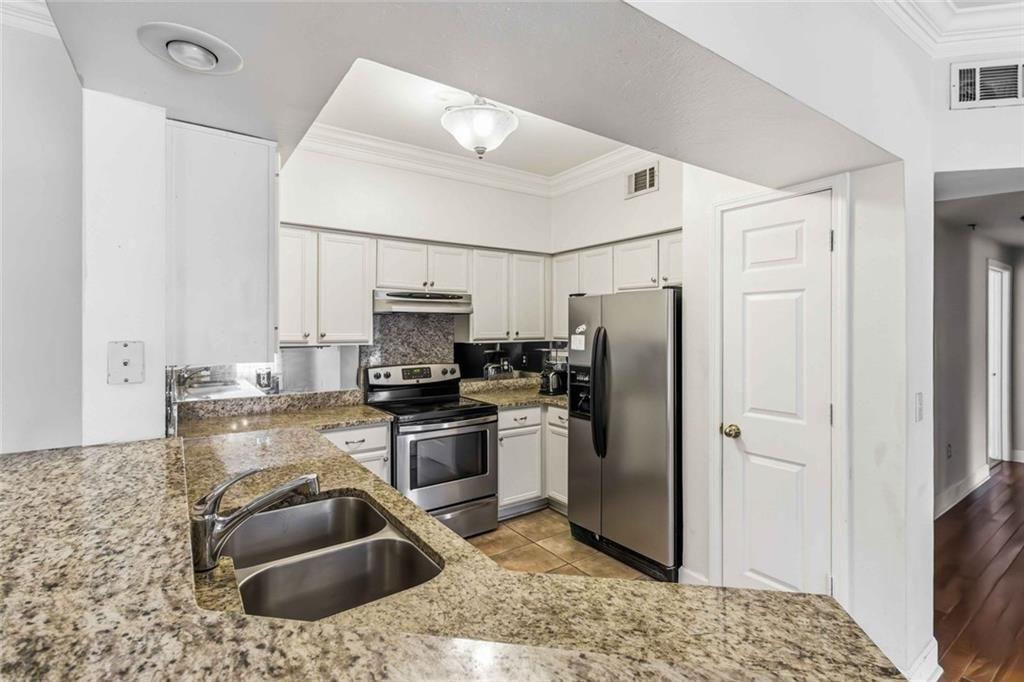 3777 Peachtree Road Northeast, Unit 533 Brookhaven, GA 30319 - Photo 6 of 30 a kitchen with stainless steel appliances granite countertop a refrigerator sink and stove