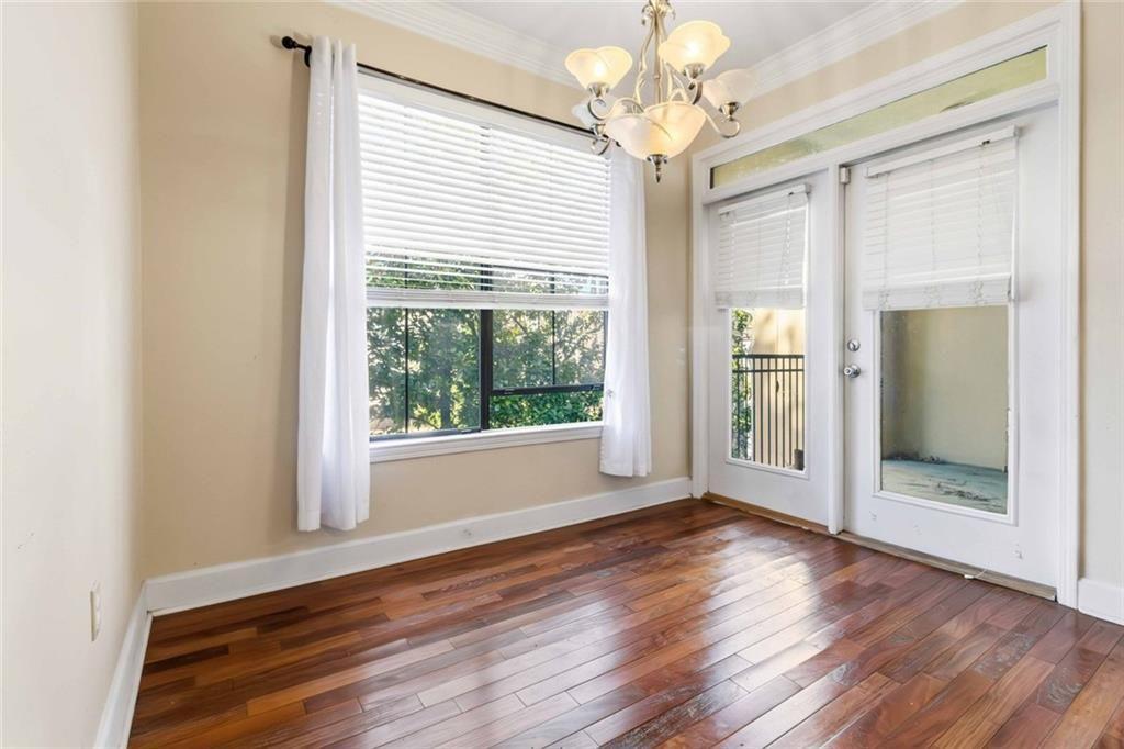 3777 Peachtree Road Northeast, Unit 533 Brookhaven, GA 30319 - Photo 9 of 30 a view of an empty room with wooden floor and a window