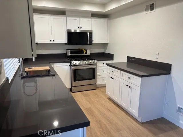 a kitchen with stainless steel appliances a sink a stove and a refrigerator