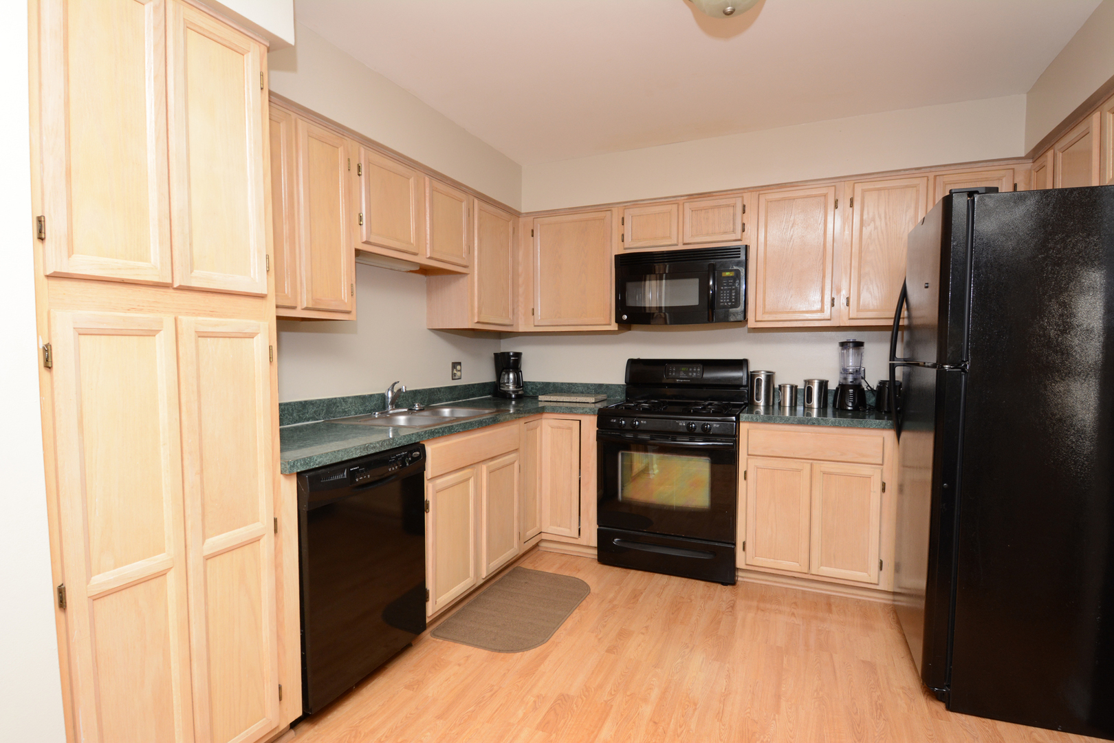 22 Tyler Court, Unit A Streamwood, IL 60107 - Photo 9 of 27 a kitchen with granite countertop a refrigerator stove top oven and sink