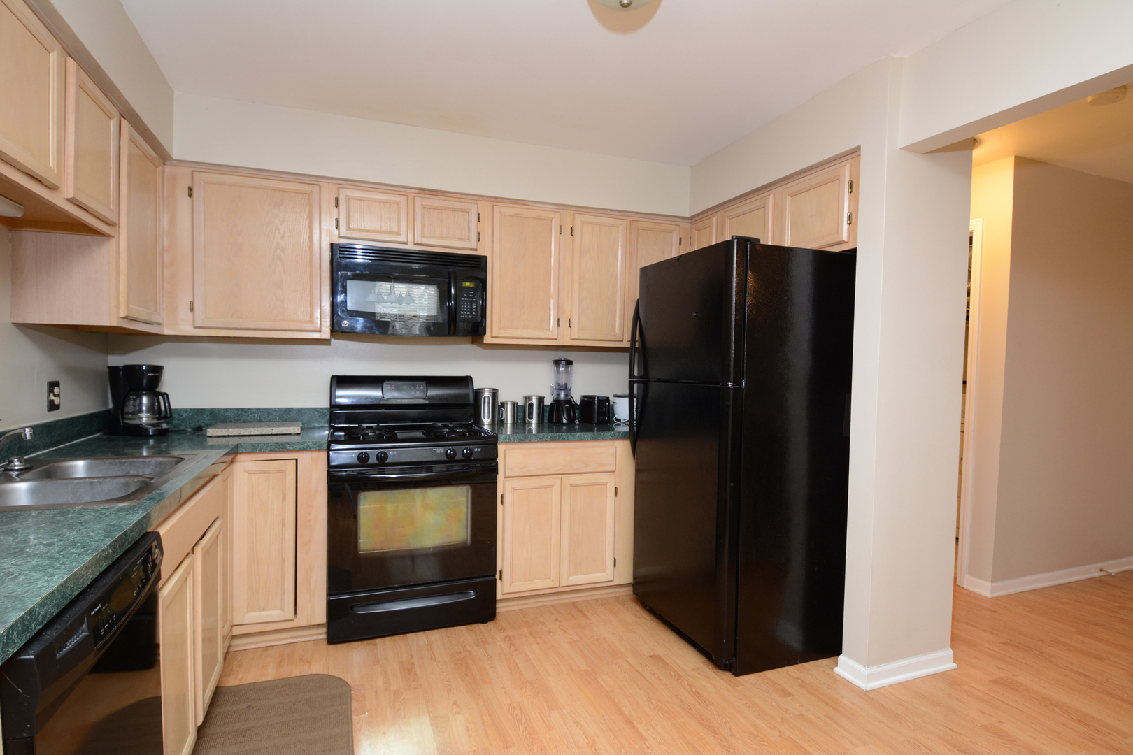 22 Tyler Court, Unit A Streamwood, IL 60107 - Photo 10 of 27 a kitchen with a refrigerator stove and wooden cabinets