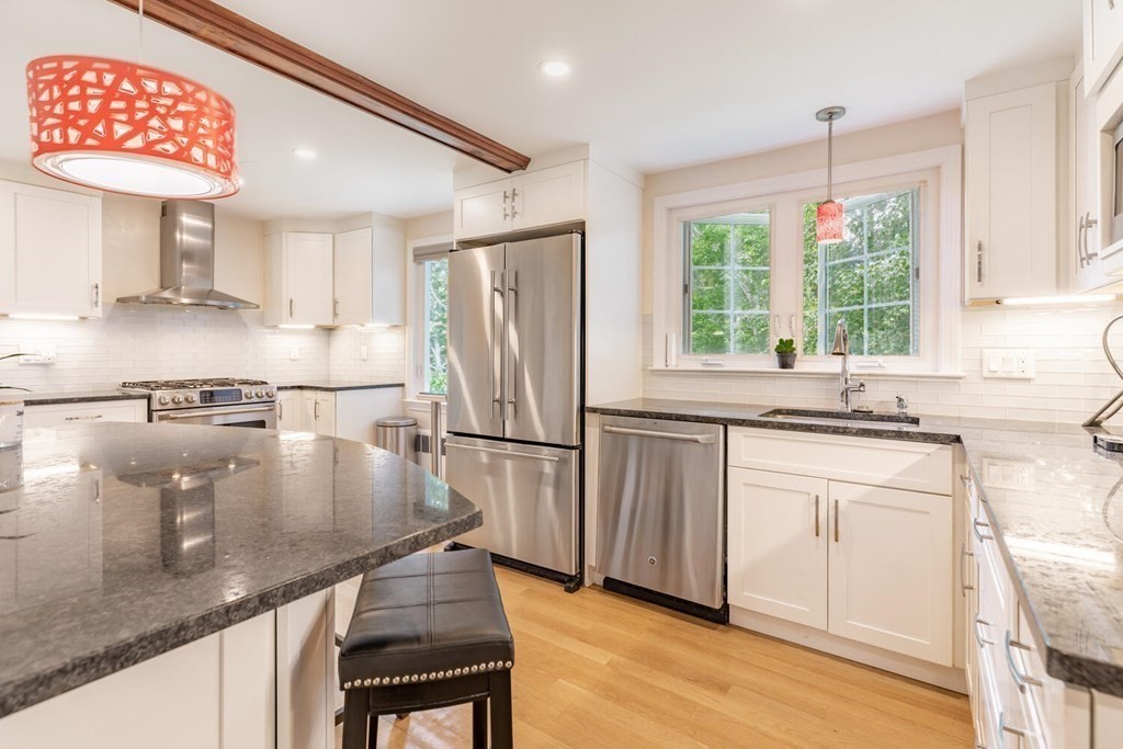 51 Ridge Street Arlington, MA 02474 - Photo 1 of 28 a kitchen with stainless steel appliances granite countertop a refrigerator a sink dishwasher a stove and white countertops with wooden floor