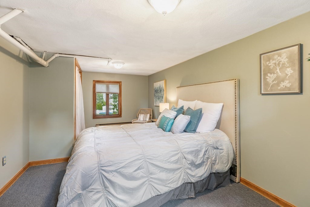 51 Ridge Street Arlington, MA 02474 - Photo 20 of 28 a large bed sitting in a bedroom next to a window and a wooden floor