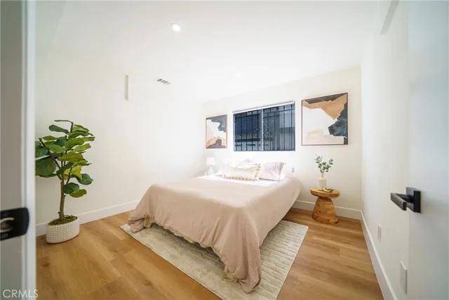 a bedroom with a bed and a potted plant
