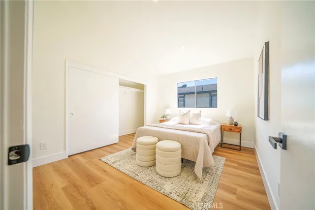 a bedroom with a bed and wooden floor
