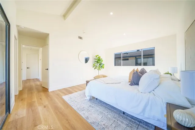 a bedroom with a bed and wooden floor