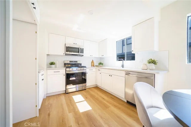 a kitchen with granite countertop white cabinets and white appliances