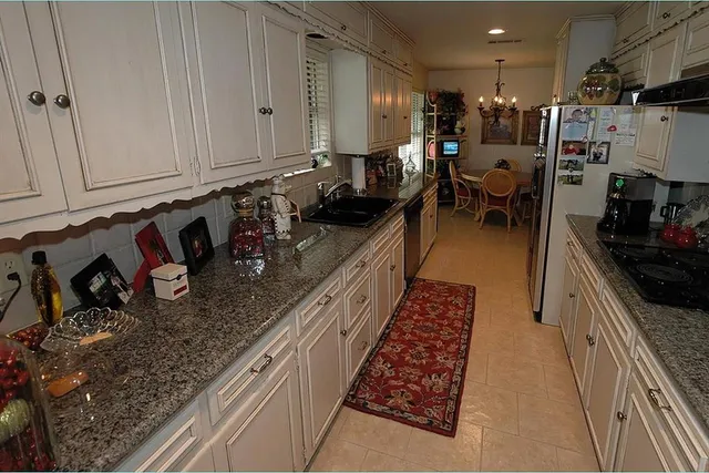 a kitchen with sink a refrigerator and cabinets