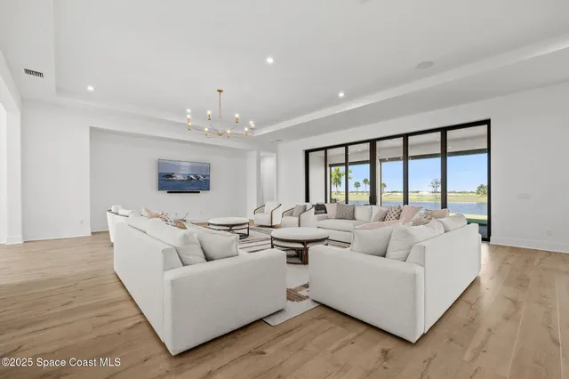 a dining room with wooden floor a chandelier a wooden table and chairs