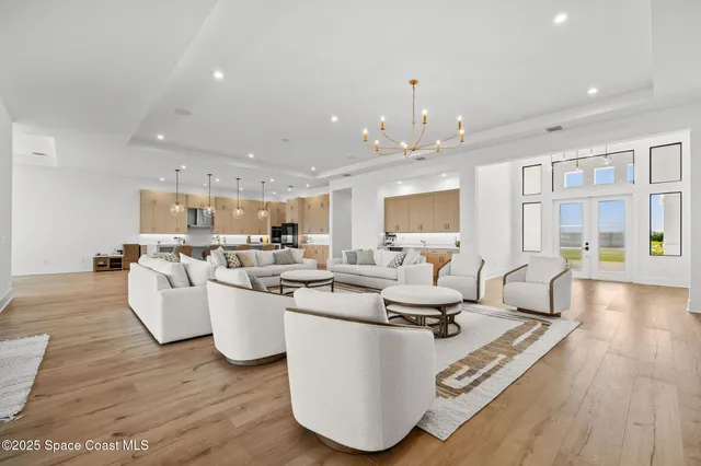 a large white kitchen with a large island oven a stove a sink a dining table and chairs