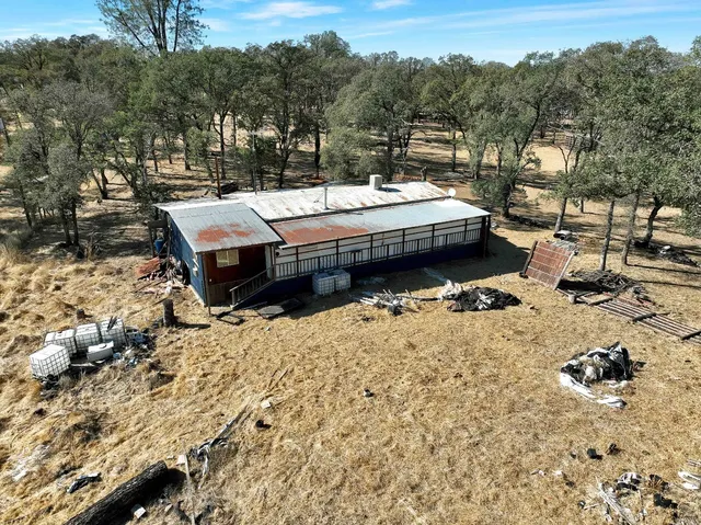 a view of dirt field with trees in the background
