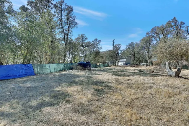 a kitchen filled with a white stove top oven and white cabinets with wooden floor