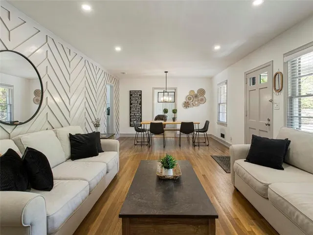 a living room with furniture a rug and a large window