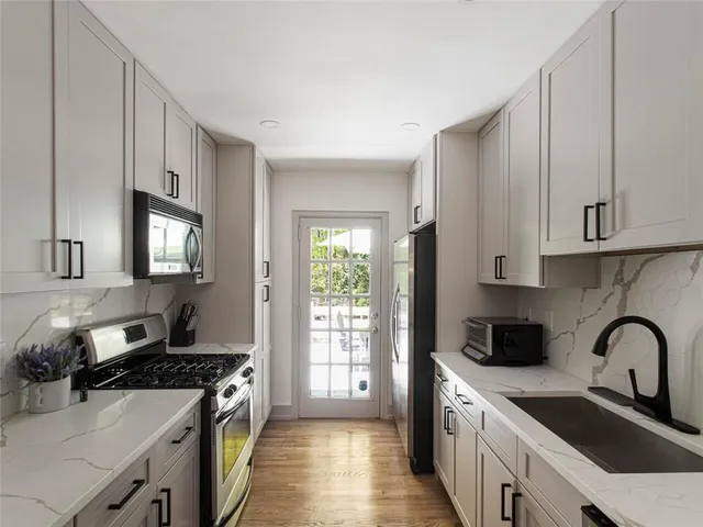 a kitchen with stainless steel appliances granite countertop a stove a sink dishwasher and a refrigerator