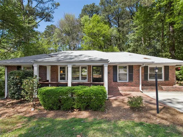 a view of a house with a yard and potted plants