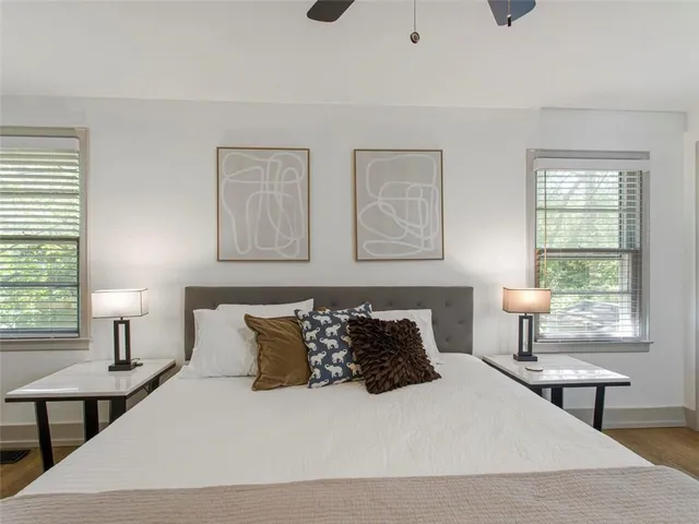 a bedroom with a bed a lamps and a window