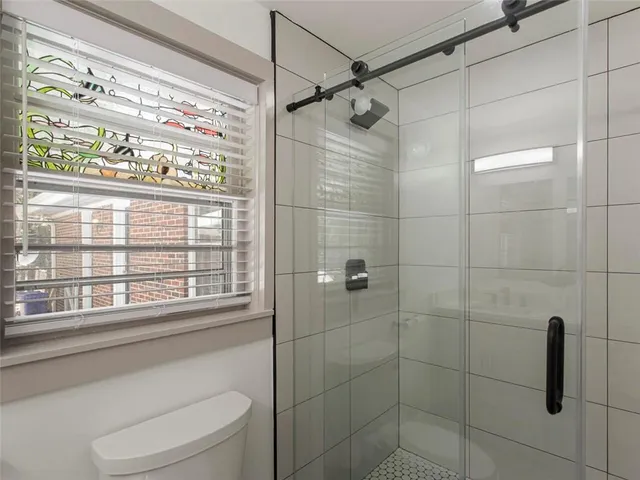 a bathroom with a shower and window