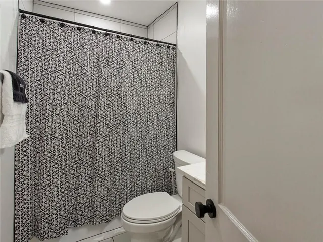 a white toilet sitting next to a white wall