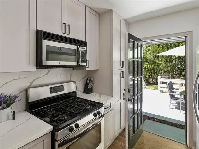 a kitchen with stainless steel appliances granite countertop a stove a microwave and a sink