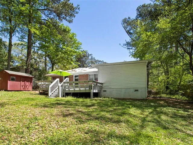 a view of a house with backyard and a tree