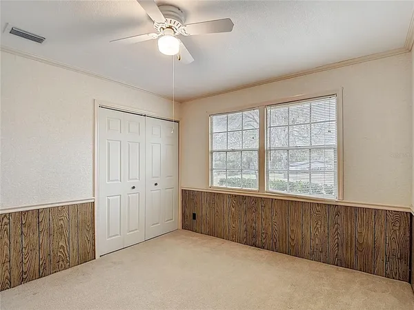 a view of a house with a yard and large tree