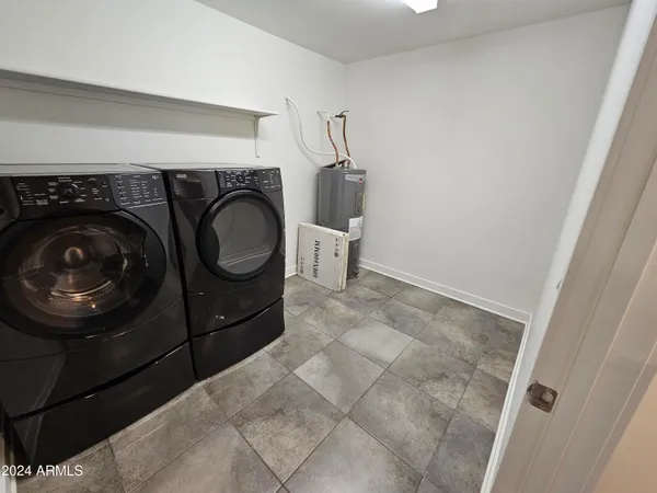 a utility room with mirror and washer