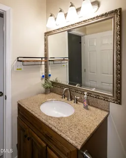 a bathroom with a granite countertop sink and a mirror