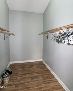 a view of a hallway with wooden floor and a bathroom