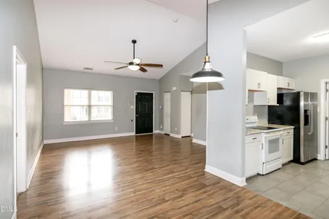 a view of a kitchen with a sink a refrigerator and a window