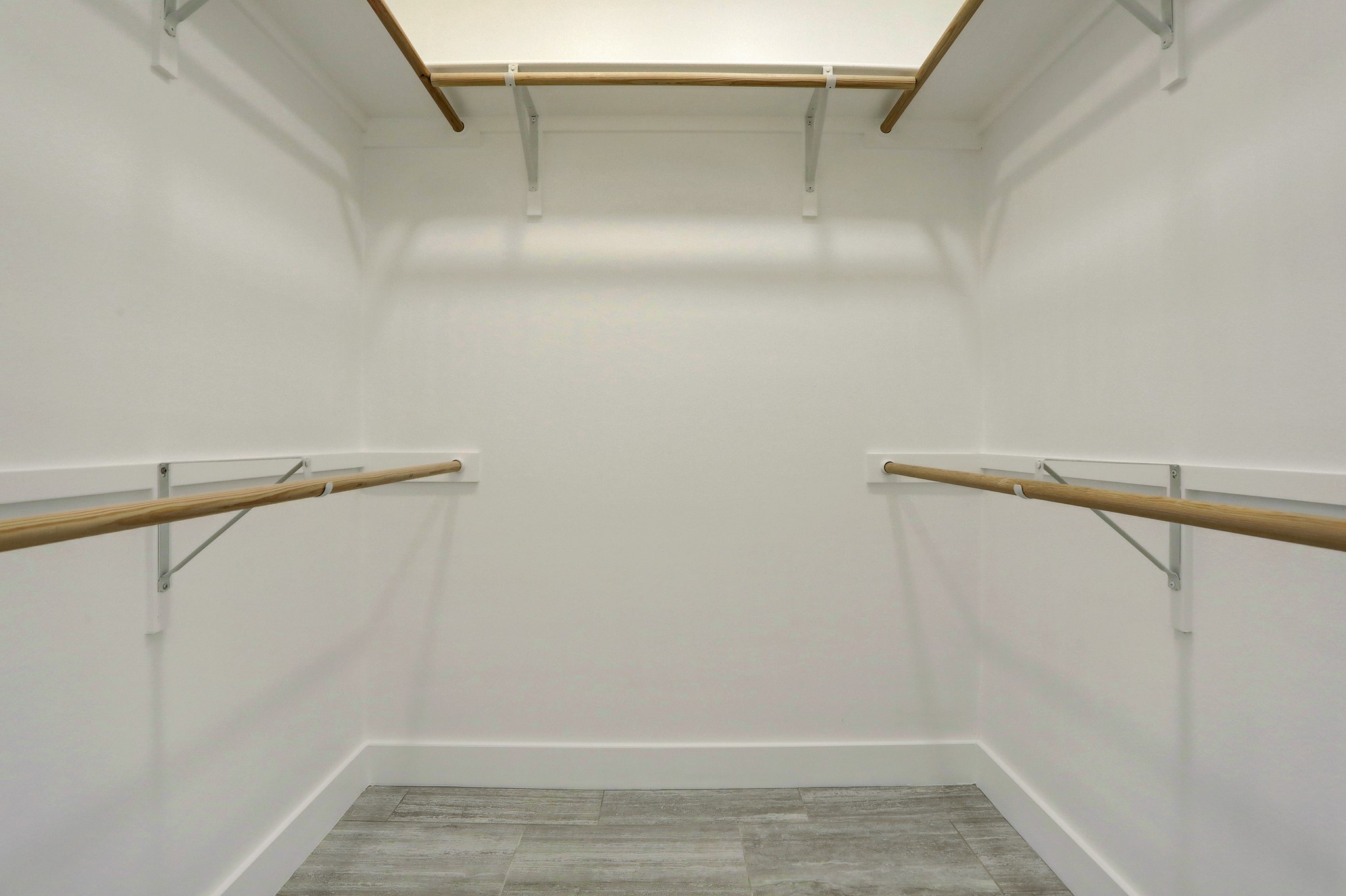 4300 Mansfield Dam Road, Unit 531 Austin, TX 78734 - Photo 19 of 32 A spacious walk-in closet boasts multiple hanging rods alongside durable tile flooring.