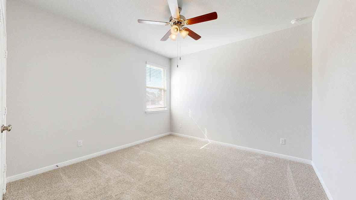 808 Gauge Road Thorndale, TX 76577 - Photo 23 of 31 A well-lit bedroom features plush carpeting and a ceiling fan for comfort.