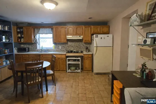 a kitchen with refrigerator and chairs