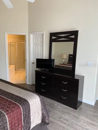 a bedroom with a bed and a mirror on dresser