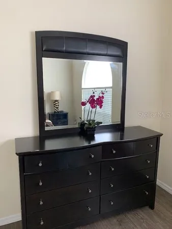 a room with a dresser a mirror and on a dresser