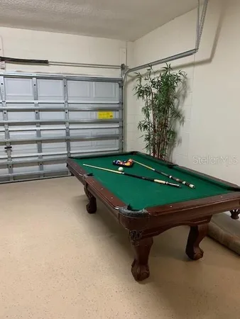 a room with pool table and windows