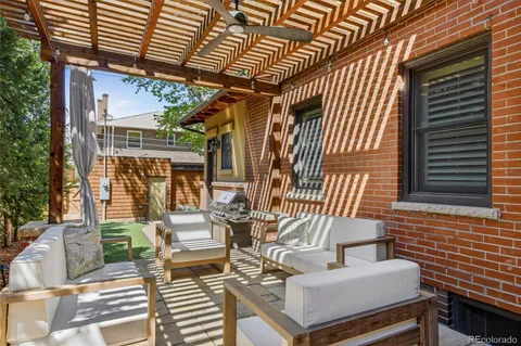 a view of a patio with couches chairs and wooden floor