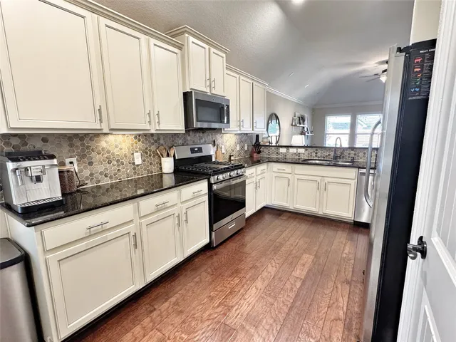 a kitchen with granite countertop white cabinets and white appliances