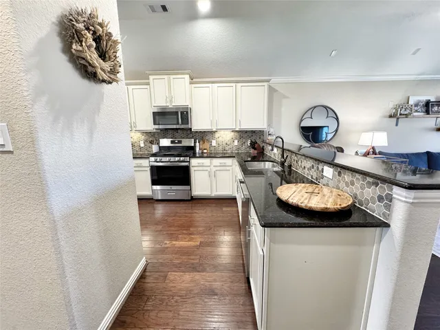a kitchen with stainless steel appliances granite countertop a stove and a sink