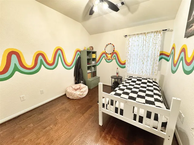 a bedroom with a bed and painting on the wall