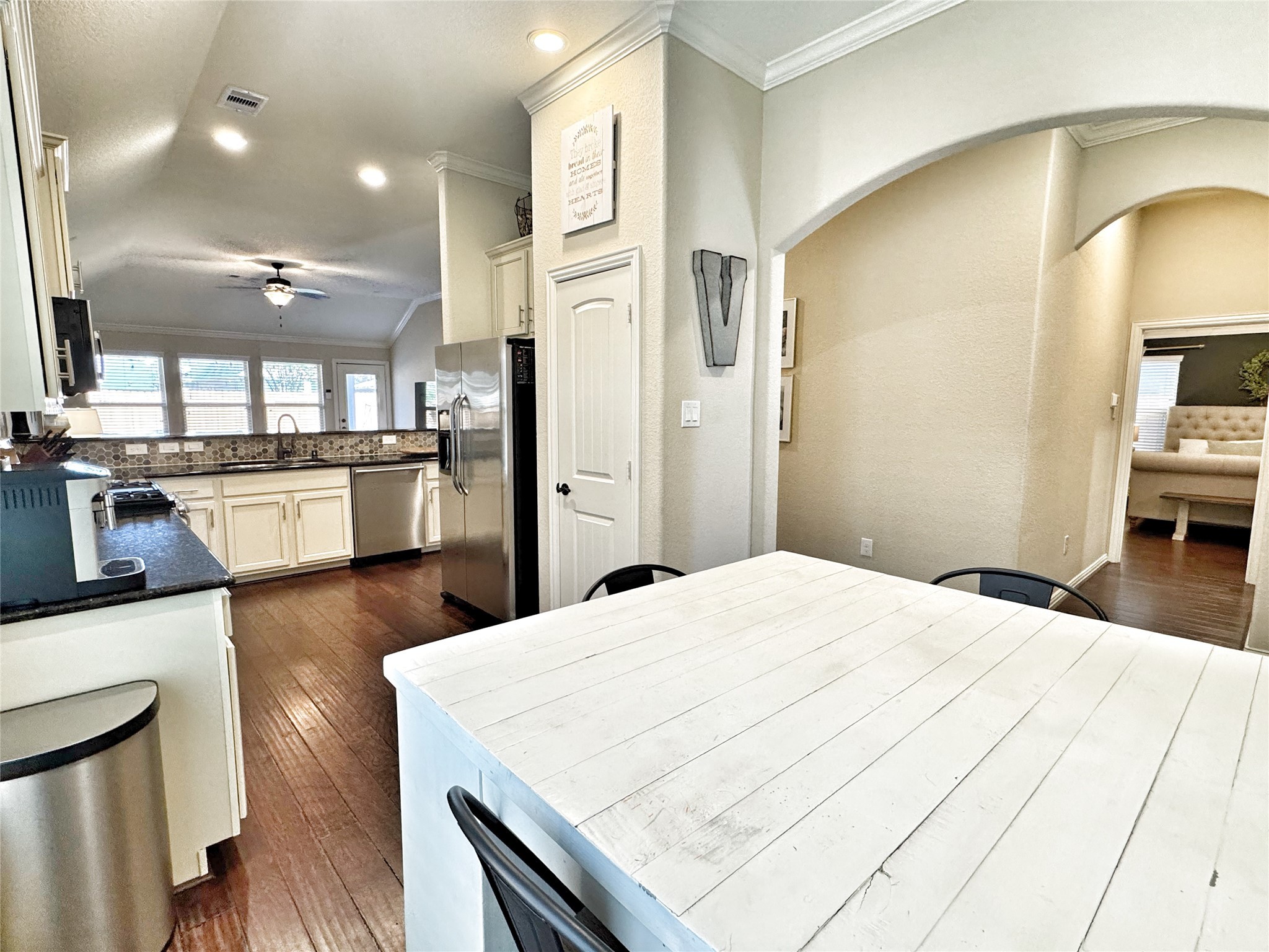 3857 Enchanted Timbers Lane Spring, TX 77386 - Photo 10 of 39 a kitchen with stainless steel appliances kitchen island granite countertop a refrigerator a stove and white cabinets with wooden floor