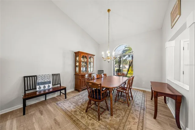 a dining room with furniture a chandelier and wooden floor