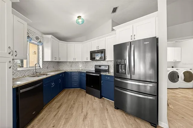 a kitchen with stainless steel appliances kitchen island granite countertop a refrigerator stove and sink