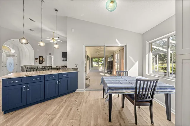 a dining room with wooden floor a chandelier a wooden table and chairs